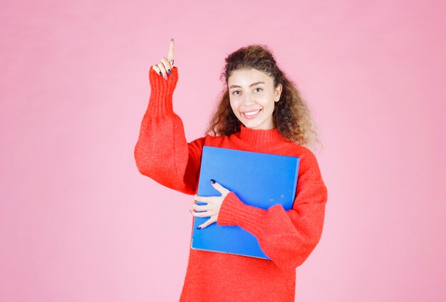 Free photo woman in a red sweatshirt pointing at different sides.