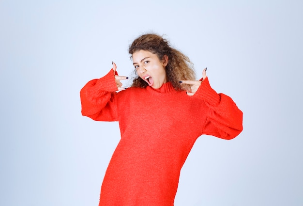 woman in red sweatshirt pointing at herself.