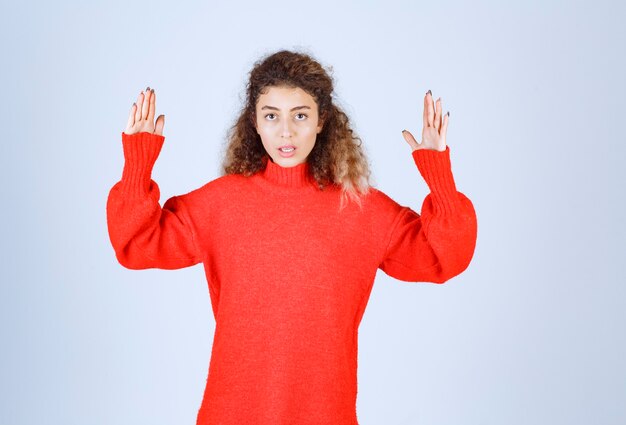 woman in red sweatshirt pointing at something up. 