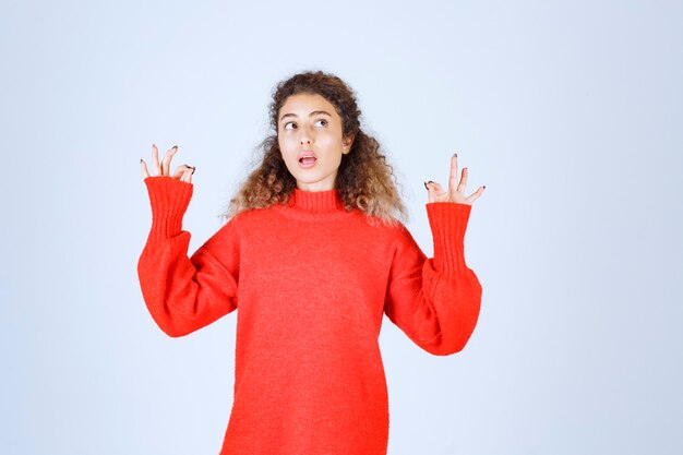 woman in red sweatshirt showing enjoyment sign. 