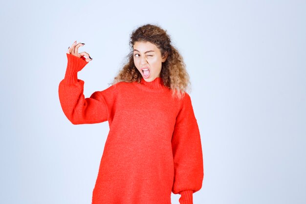 Free photo woman in red sweatshirt showing enjoyment sign.