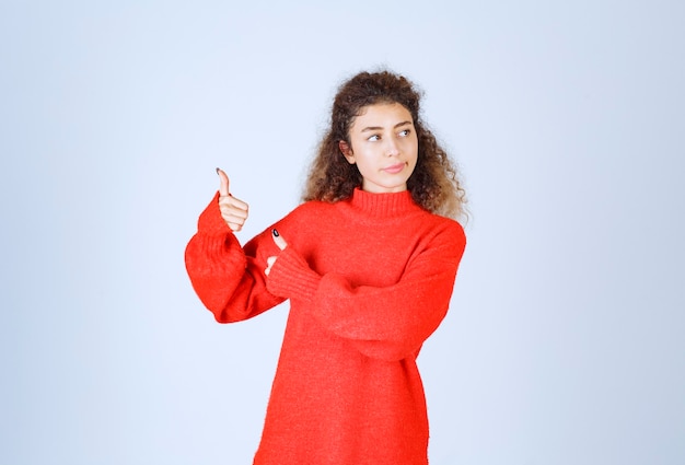 woman in red sweatshirt showing enjoyment sign.