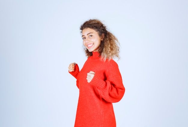 woman in red sweatshirt showing her fist and meaning her power. 