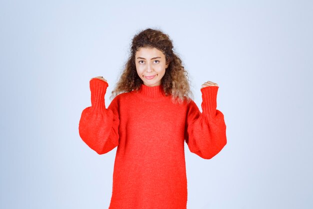 woman in red sweatshirt showing her fists.