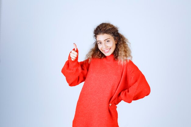 woman in red sweatshirt showing peace and enjoyment sign. 