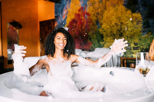 Woman relaxed in the hydro massage bath covered in foam