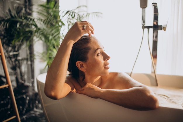 Женщина, расслабляющаяся в ванне с пузырьками