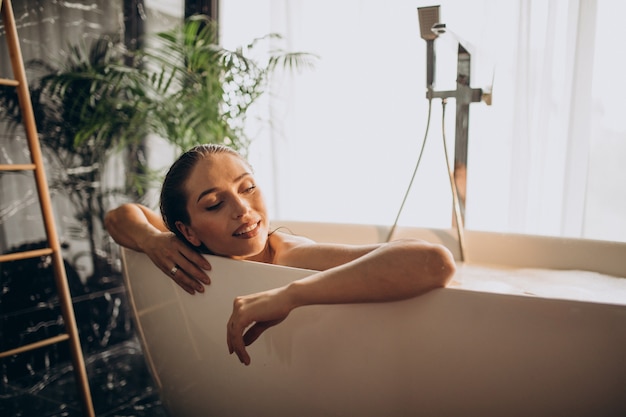 Foto gratuita donna che si distende nella vasca da bagno con le bolle