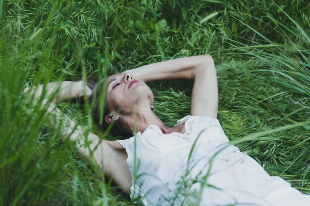 Женщина, расслабляющий на траве