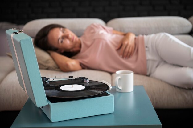 woman relaxing at home while listening to vinyl music