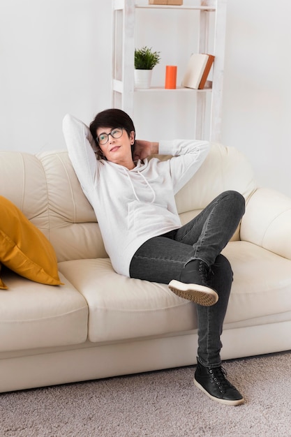 Женщина отдыхает на диване у себя дома