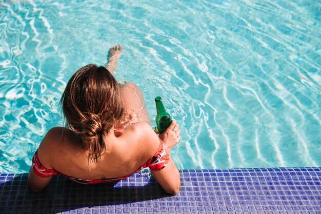 Woman relaxing next to swimming pool