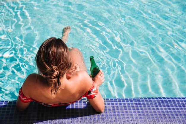 Женщина, расслабляющая рядом с бассейном