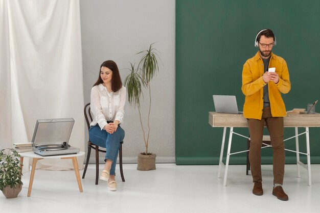 Woman relaxing while reading book and man using mobile