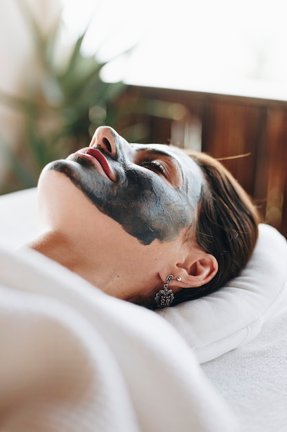 Foto gratuita donna che si distende con una maschera facciale presso la spa