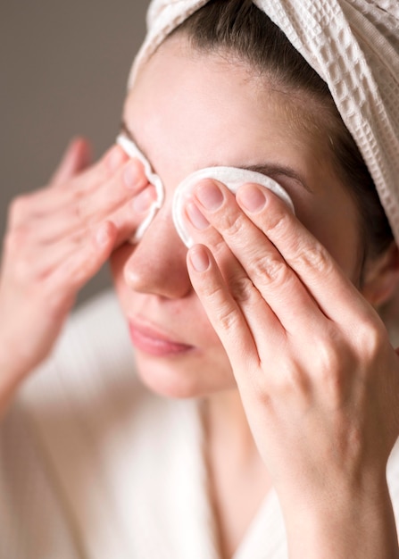 Woman removing eye shadow with micellar water
