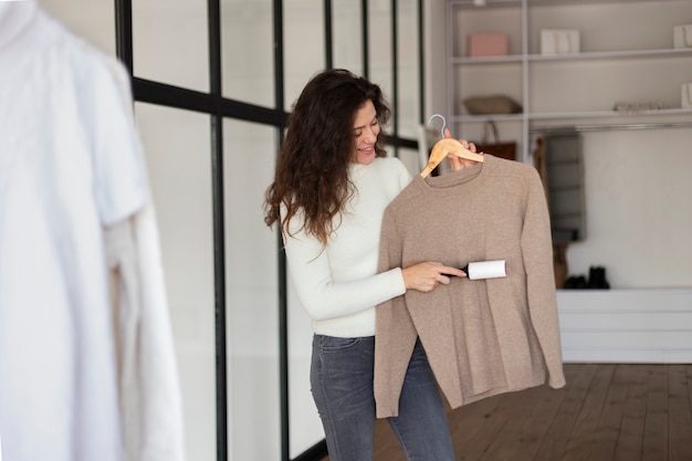 Woman removing lint from sweater