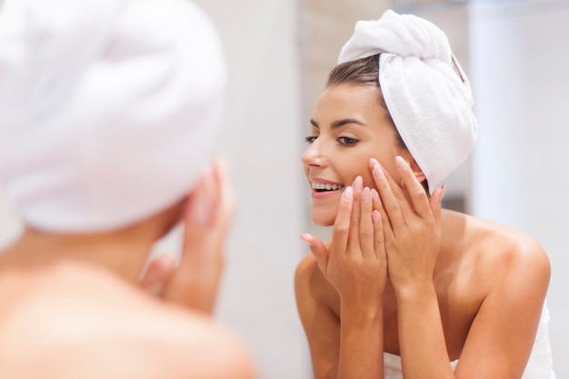 Free photo woman removing pimple from her face