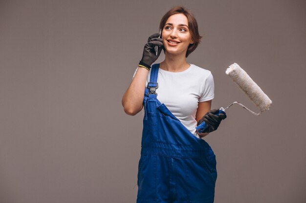 Woman repairer with painting roller isolated talking on the phone