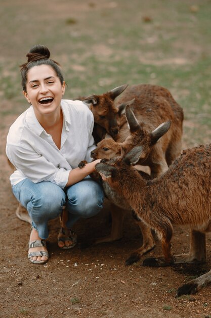 Woman in the reserve is playing with a kangaroo