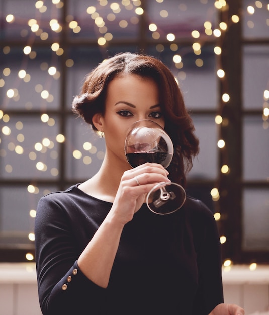 Free photo woman in restaurant holding a wine glass