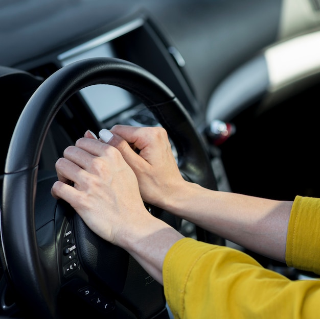 Woman resting her hands on steering wheel