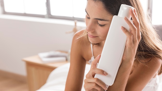 Woman resting her head on a body lotion container