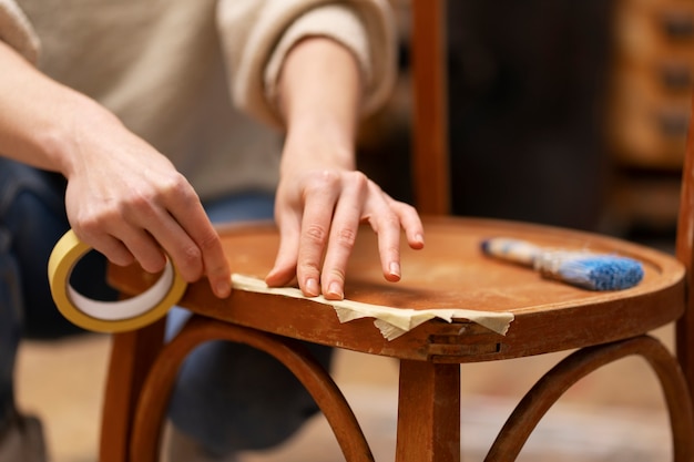Free photo woman restoring wooden chair front view