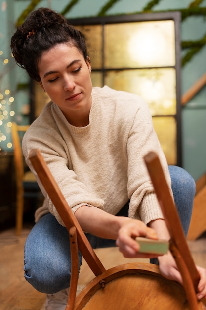 Woman restoring wooden chair  full shot