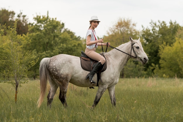 Woman ridding a horse in the countryside 