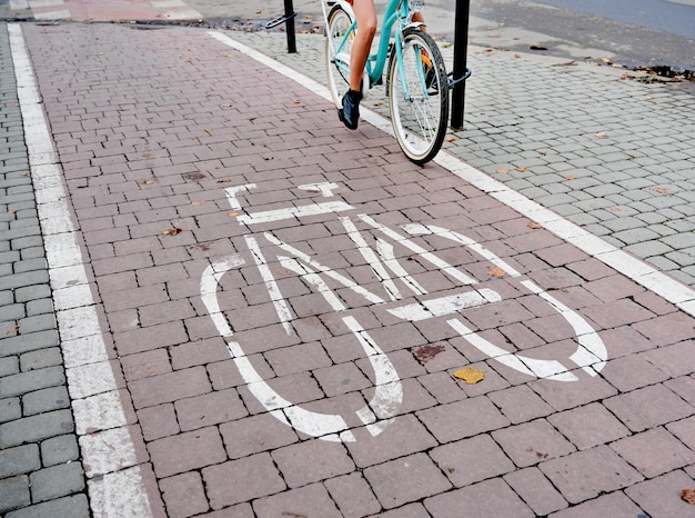Женщина едет по велосипедной дорожке в центре города