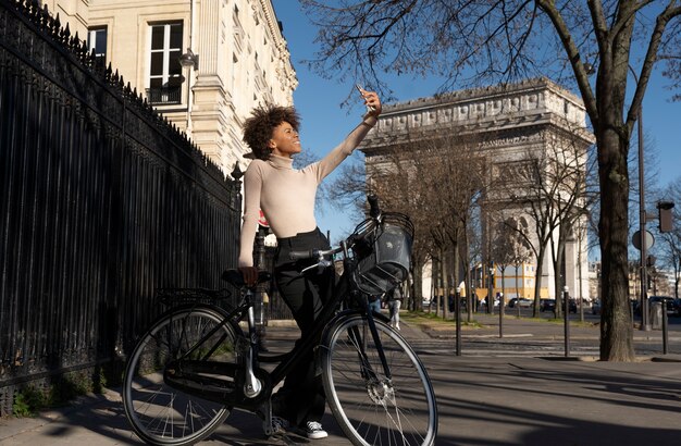 Woman riding the bike and taking selfie in the city in france