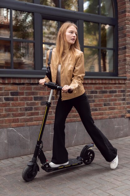 Woman riding electric scooter outdoors in the city