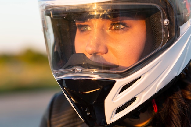 ヘルメットをかぶった彼女のバイクに乗る女性