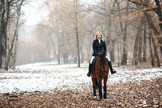 Woman riding horse in woods