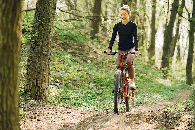 森の中のマウンテンバイクに乗る女性