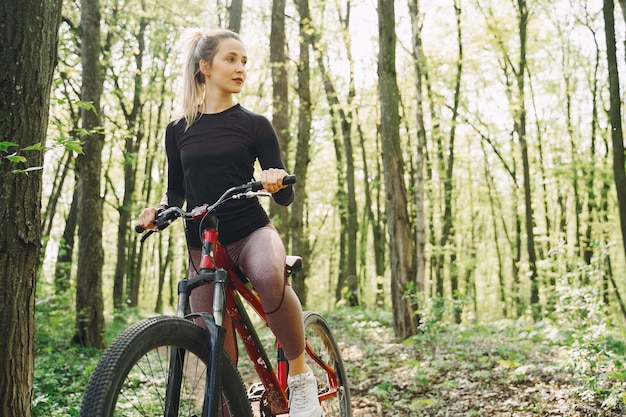 숲에서 산악 자전거를 타는 여자