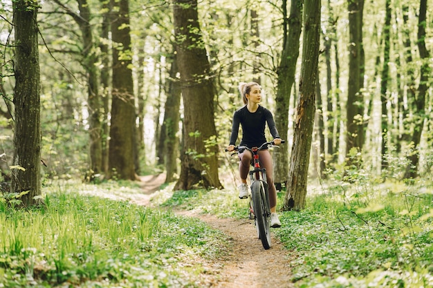森の中のマウンテンバイクに乗る女性
