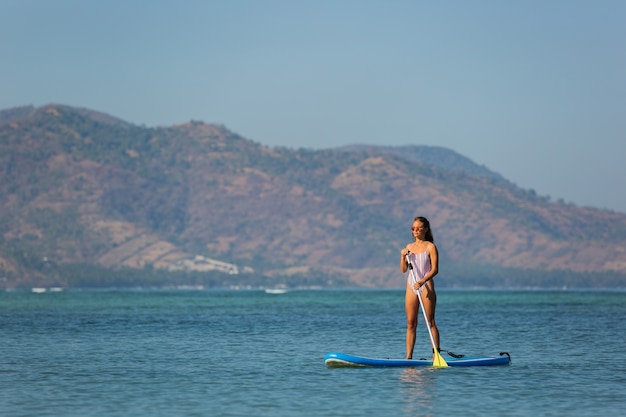 Foto gratuita donna a cavallo sup. . bali. indonesia