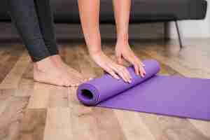 Free photo woman rolling yoga mat