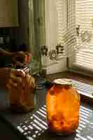 Free photo a woman rolls a compote in a large jar under the sun in summer at home in the village