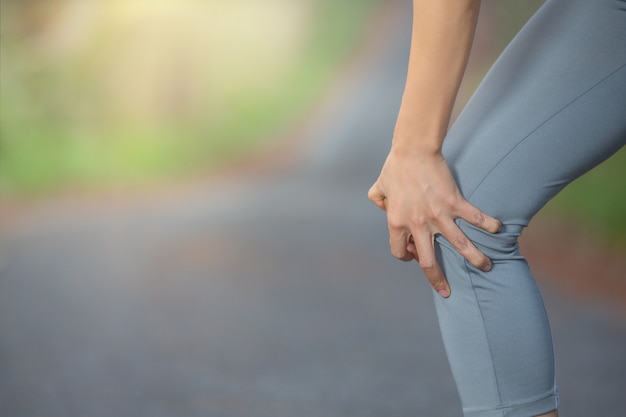 Foto gratuita donna corridore tenere dolore al ginocchio