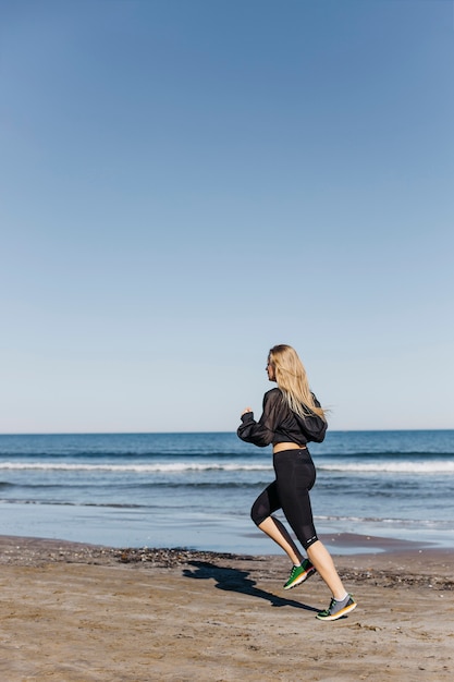 Foto gratuita donna che corre in spiaggia