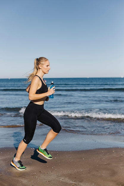 Free photo woman running at the beach