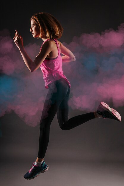 Woman running in blue and pink smoke