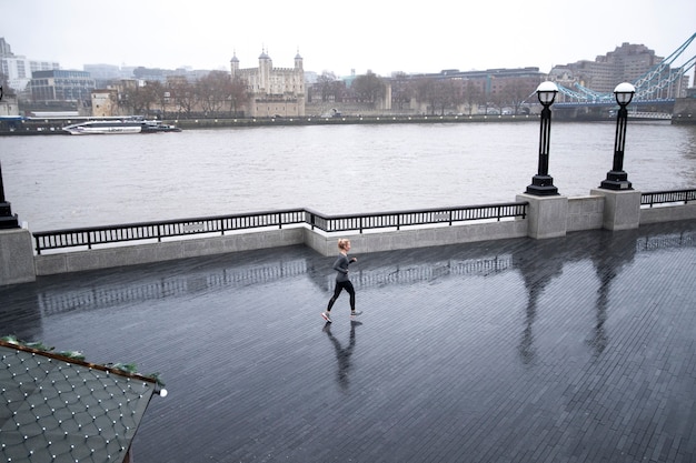 Foto gratuita donna che corre e fa i suoi esercizi fuori mentre piove