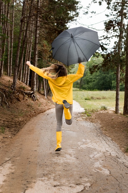 Женщина работает в лесу, держа зонтик