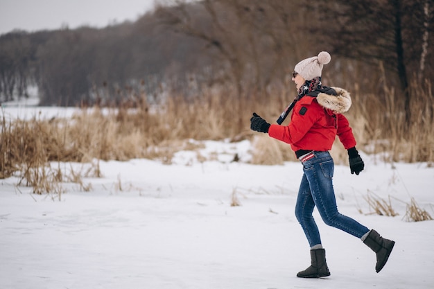 Donna che funziona sul lago in inverno