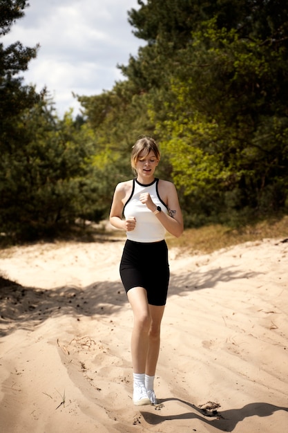 Woman running in nature front view
