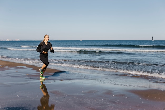 Woman running at shoreline
